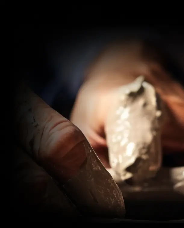 Manos de un artesano pintando meticulosamente una botella de cerámica